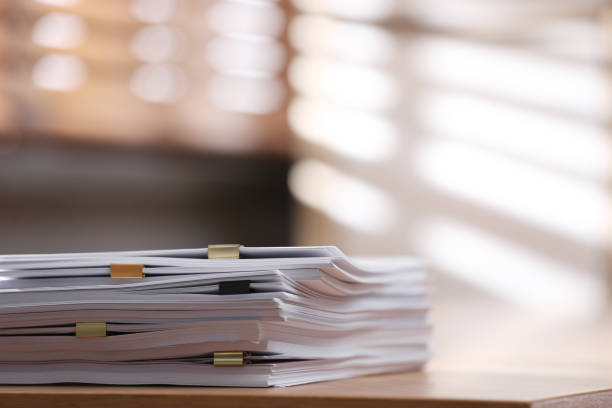 Stack of blank paper with binder clips on wooden table indoors. Space for text Stack of blank paper with binder clips on wooden table indoors. Space for text